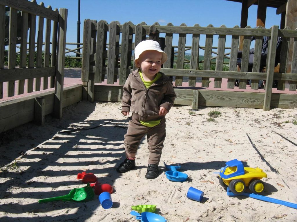 Niño sonriente en un parque de arena